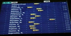 A race projected onto a big screen, with each rower's boat in its own lane